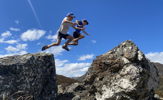 boys jumping between rocks